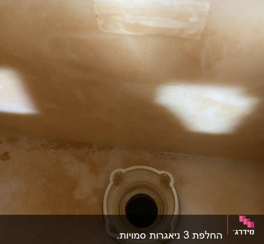 חלק פנימי של מיכל שירותים עם פתח ניקוז